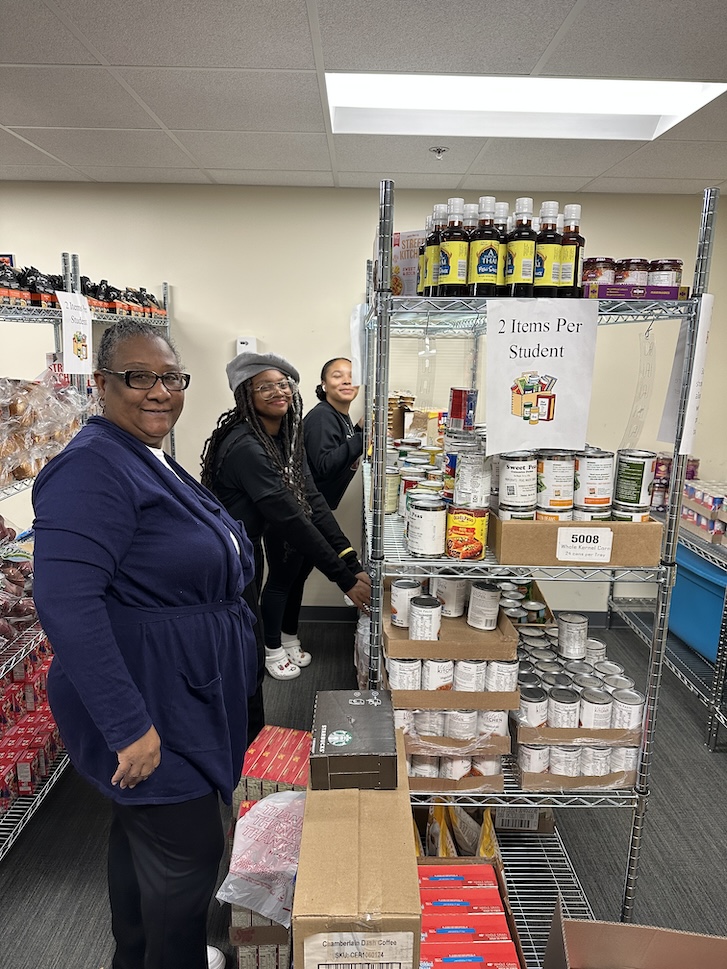 Staff members and students in GovState Food Pantry aisle